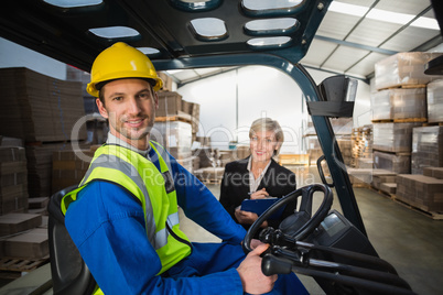 Warehouse worker and his manager smiling at camera Warehouse worker and his manager smiling at camera