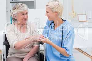 Female nurse checking flexibility of patients wrist