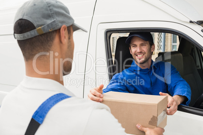 Delivery driver handing parcel to customer in his van