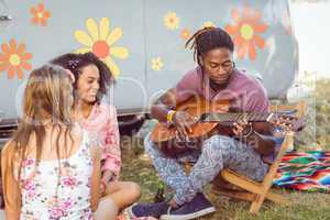 Hipster playing guitar for his friends