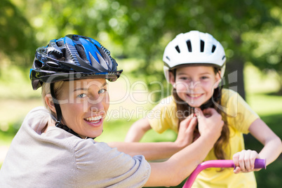 Mother attaching her daughters cycling helmet