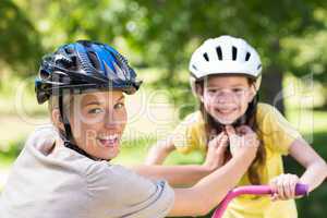 Mother attaching her daughters cycling helmet