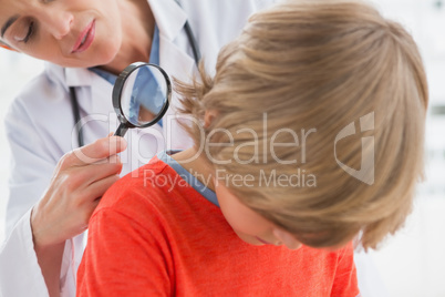 Doctor examining patient with magnifying glass