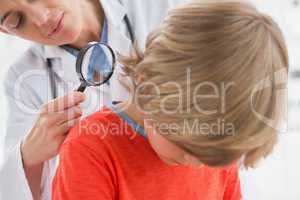 Doctor examining patient with magnifying glass