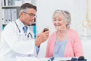 Doctor showing medicine bottle to female patient