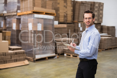 Manager looking at camera while holding clipboard