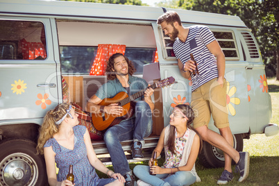 Hipster playing guitar for his friends