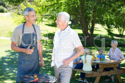 Happy man doing barbecue with his father