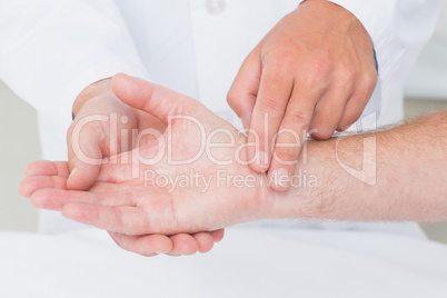 Male doctor checking patients pulse