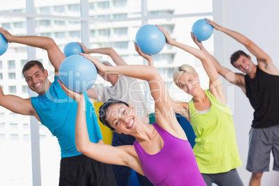 Instructor with class exercising with fitness balls