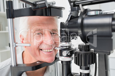 Senior patient using slit lamp at clinic Senior patient using slit lamp at clinic