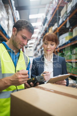 Worker and manager scanning package in warehouse