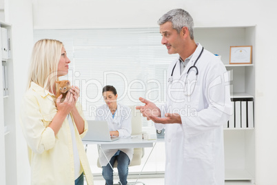 Veterinarian explaining things at cat owner