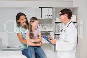 Doctor examining little girl with her mother