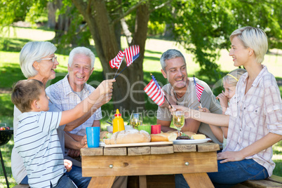 Happy family having picnic and holding american flag