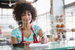 Smiling waitress writing on notepad