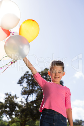 Happy little girl holding balloons