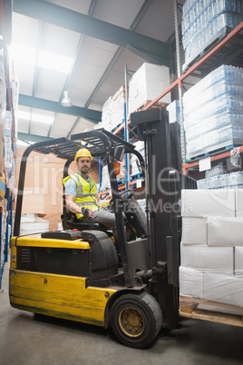 Smiling driver operating forklift machine