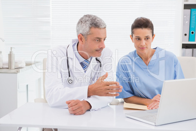 Doctors looking at laptop