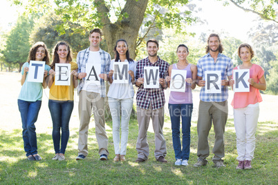 Friends holding teamwork signs in the park