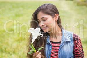 Pretty brunette smelling a flower