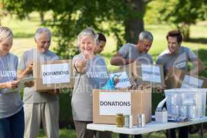 Happy family holding donations boxes with thumb up