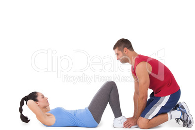 Trainer with woman doing sit ups