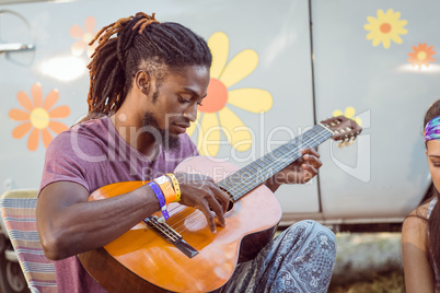 Hipster playing guitar for his friends