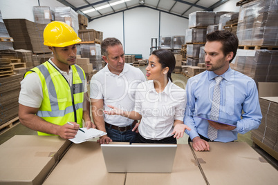 Warehouse managers and worker talking together