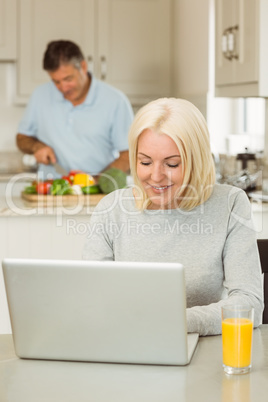 Happy mature blonde using laptop