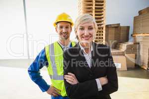 Portrait of smiling warehouse worker and his manager