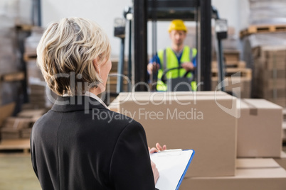 Rear view of warehouse manager in front of her colleague