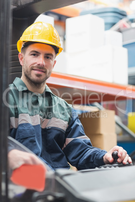 Driver operating forklift machine in warehouse