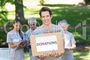 Happy volunteer man holding donation box