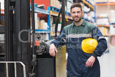 Manual worker leaning against the forklift