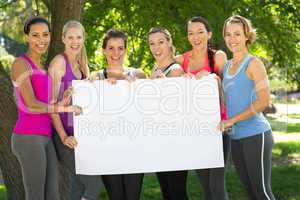 Fitness group holding poster in park
