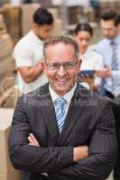 Boss wearing eyeglasses standing with arms crossed