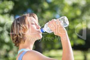 Fit blonde in the park drinking water