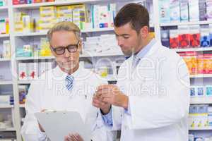 Senior pharmacist writing on clipboard