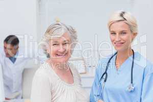 Nurse and senior patient smiling in clinic