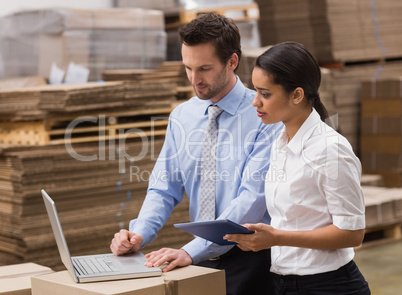 Warehouse managers working on laptop