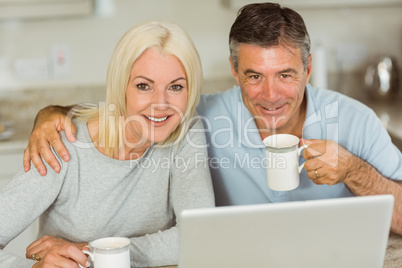 Happy mature couple using laptop