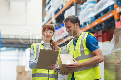 Smiling warehouse manager and delivery man