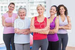 Confident female friends standing arms crossed