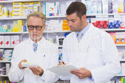 Team of pharmacists looking at medicine box