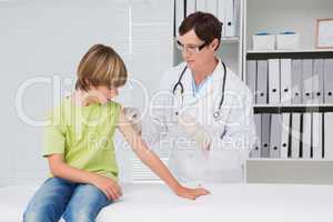 Doctor doing injection at little boy