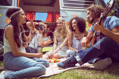 Hipster friends by camper van at festival