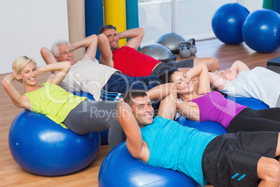 Happy people stretching on exercise balls