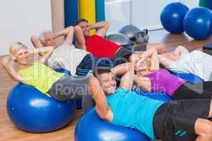 Happy people stretching on exercise balls