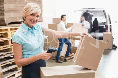 Smiling warehouse manager scanning package